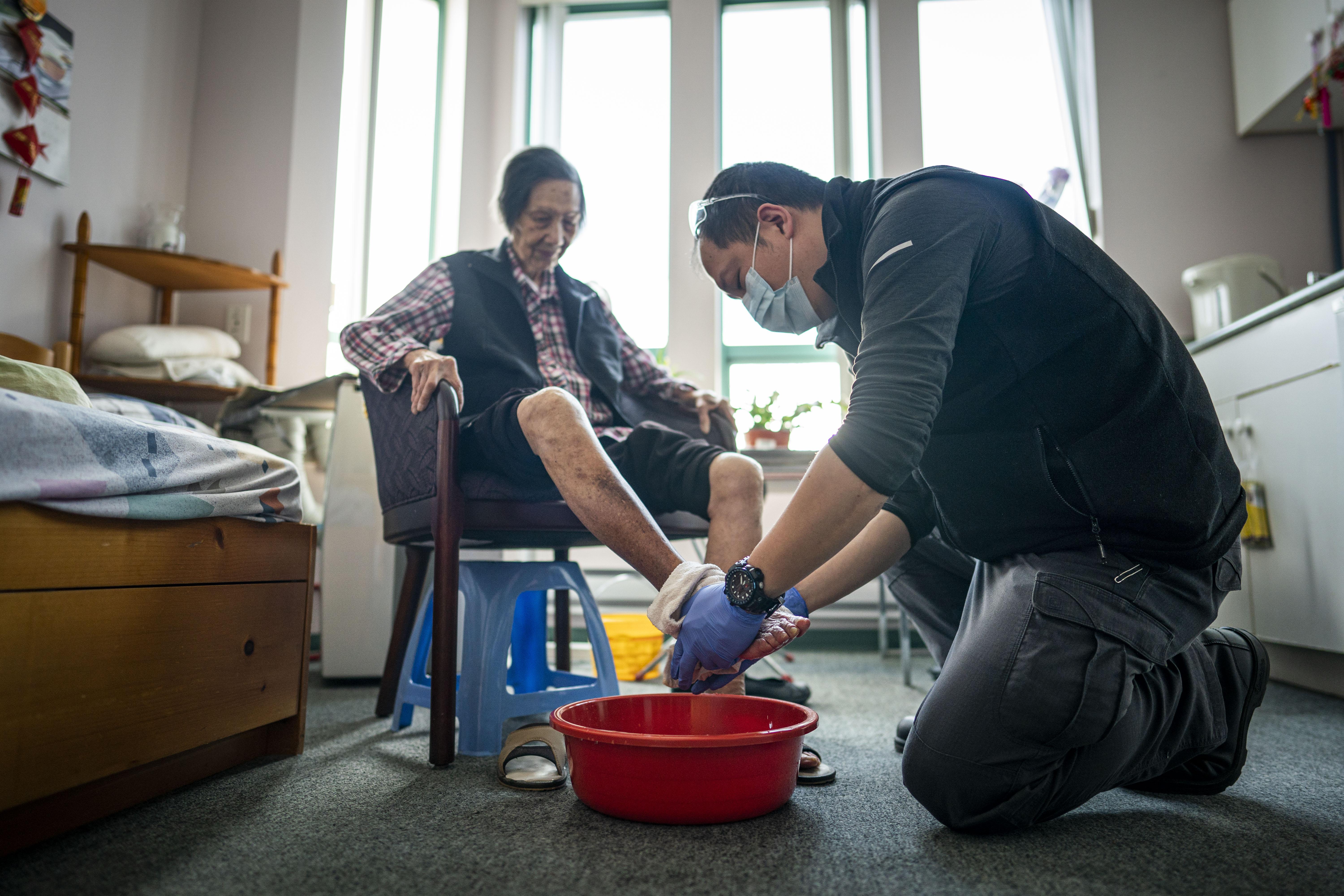 home support worker washes a clients feet